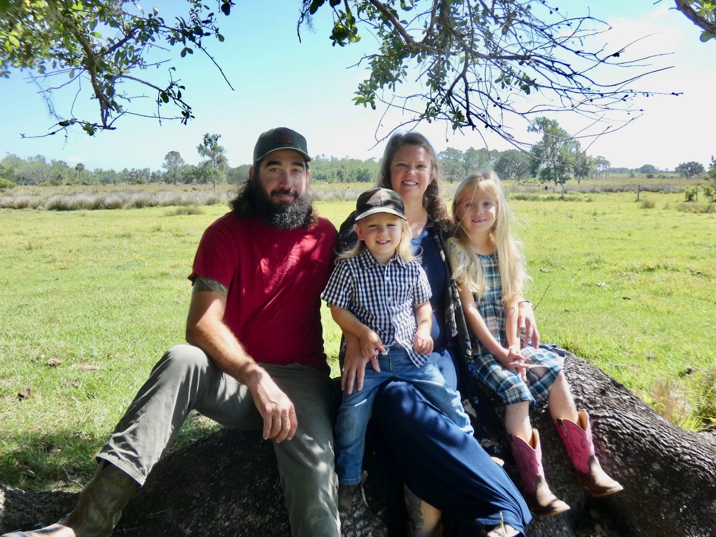Ricky and Talia Quigg with their two children in a green Florida pasture